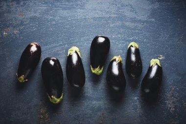 Mavi zemin üzerinde taze patlıcanlar, üst görünüm.