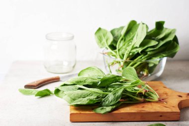 Kesme tahtasındaki taze yeşil ıspanak yaprakları..