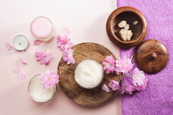 Doğal kozmetik cilt bakımı. Vücut bakım kremi ve pembe kiraz çiçekleri..