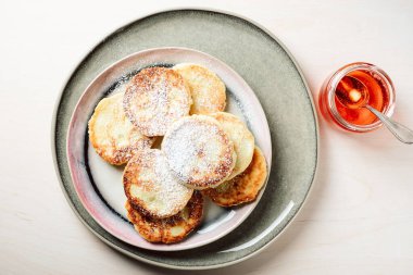 Açık ahşap arka planda ballı süzme peynir krepleri..