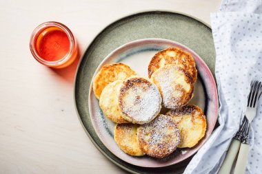 Açık ahşap arka planda ballı süzme peynir krepleri..