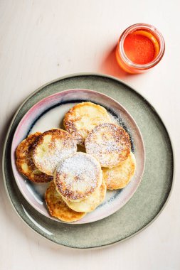 Açık ahşap arka planda ballı süzme peynir krepleri..