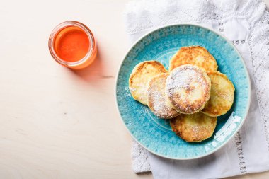 Açık ahşap arka planda ballı süzme peynir krepleri..
