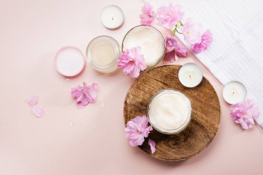 Vücut bakım kremi ve pembe kiraz çiçekleri. Düz yatıyordu.