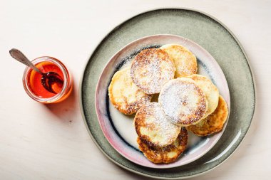 Açık ahşap arka planda ballı süzme peynir krepleri..