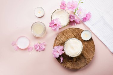 Vücut bakım kremi ve pembe kiraz çiçekleri. Düz yatıyordu.