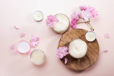 Doğal kozmetik cilt bakımı. Vücut bakım kremi ve pembe kiraz çiçekleri..