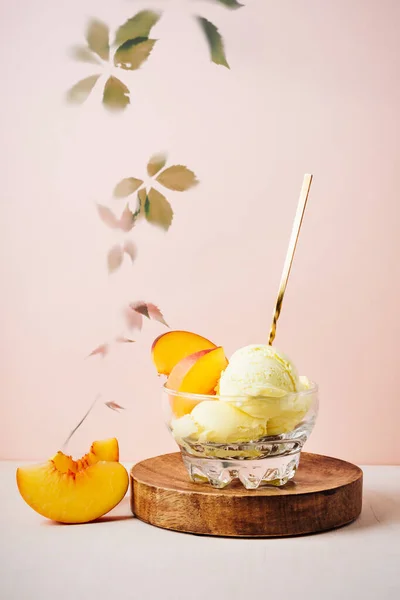 Glass of peach ice cream with a spoon.