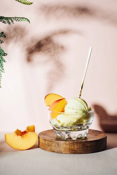 Glass of peach ice cream with a spoon.