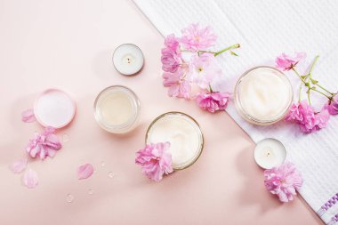 Vücut bakım kremi ve pembe kiraz çiçekleri. Düz yatıyordu.