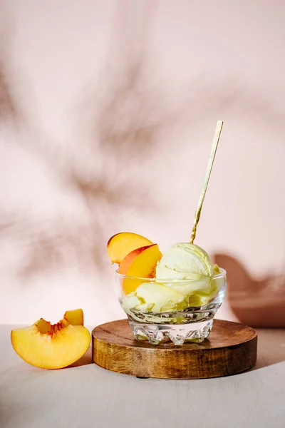 Glass of peach ice cream with a spoon.