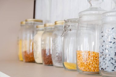 Baharat ve tahıl kavanozlarıyla dolu ahşap dolap.