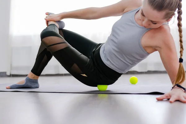 Žena použití Myofascial uvolnění masážní koule na kyčli Stock Snímky