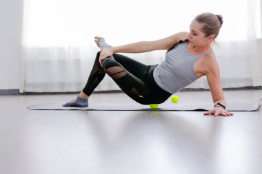 Kadın, kalça seçici odak için Myofascial masaj toplarını kullanır.