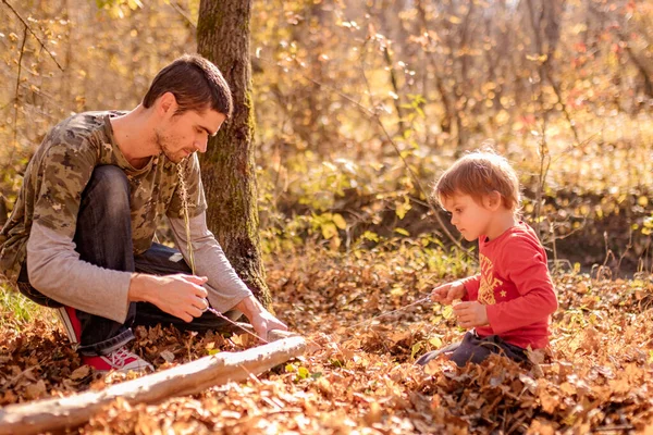 Father and son saw a log with a wire saw in camp autumn — Stock Photo, Image