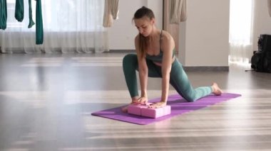 Kadın avuçlarını mor yoga bloklarına yaslıyor. Tam HD