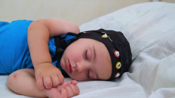 뇌파 검사를 받는 동안 침대에서 자고 있는 아기 — 비디오