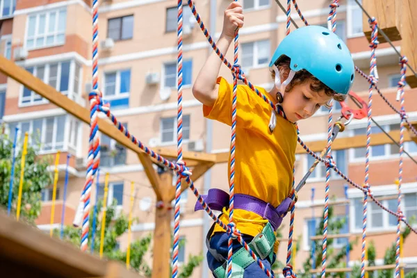 Pojke korsning kurs höga rep element i äventyrspark utomhus. Koncept Klättring extrem sport, fysisk utveckling — Stockfoto