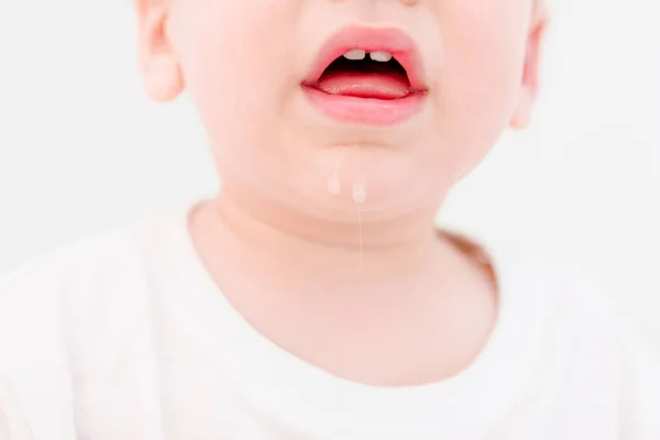 Primer plano de la boca del bebé con dos dientes. La baba está babeando por su boca. concepto de dentición dolorosa, niños llorando — Foto de Stock