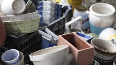 Toprakla kaplı bitkiler için bir sürü boş ve seramik kap.