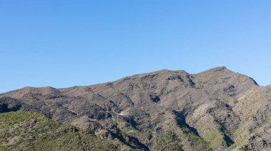 Güneşli bir günde mavi gökyüzü olan dağ sıraları