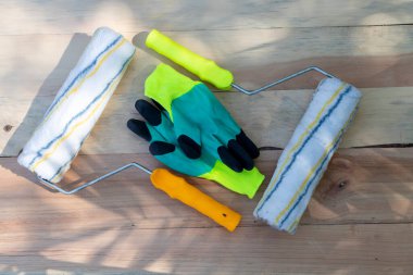 Ahşap bir arka planda boya ve çalışma eldivenleri.