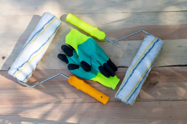 Ahşap bir arka planda boya ve çalışma eldivenleri.