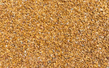 lose up of small stone texture. Abstract background of decorative floor, pebble stones. Gravel, yellow-orange road in the park.