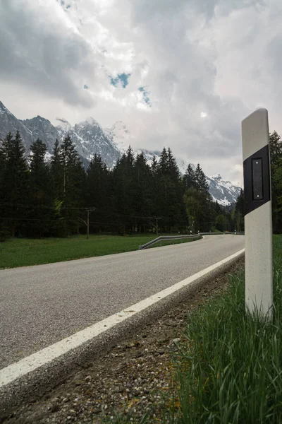 Zugspitze Dağı. Dağlara giden yol. Bavyera Alpleri. Almanya. Ormandan güzel dağ manzaraları görülebilir..