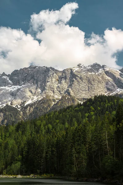 Zugspitze Dağı ve Eibzee Gölü. Bavyera Alpleri. Almanya. Ormandan güzel dağ manzaraları görülebilir..