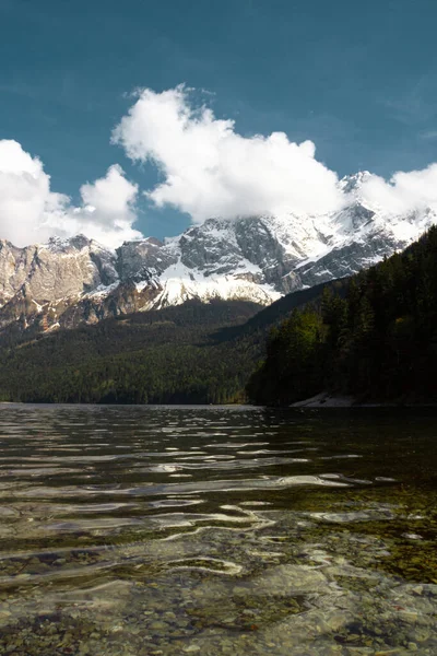 Zugspitze Dağı ve Eibzee Gölü. Bavyera Alpleri. Almanya. Ormandan güzel dağ manzaraları görülebilir..