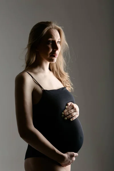 Hamile bir kadın beyaz arka planda karnını okşuyor. Uzayı kopyala Sağlıklı sindirim, yaşam tarzı, lvf — Stok fotoğraf