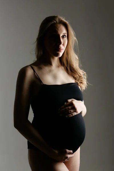 Mulher grávida acariciando a barriga no fundo branco. Espaço para cópia. O conceito de digestão saudável, estilo de vida, FIV — Fotografia de Stock