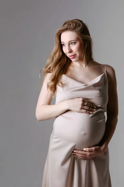 Mujer embarazada caucásica acariciando su vientre sobre fondo blanco. Copiar espacio. El concepto de digestión saludable, estilo de vida, FIV —  Fotos de Stock