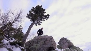 Rahip dağda vaaz veriyor. Papaz kıyafetleri giymiş bir adam bir taşın üzerinde duruyor. Dağlarda kış ve soğuk