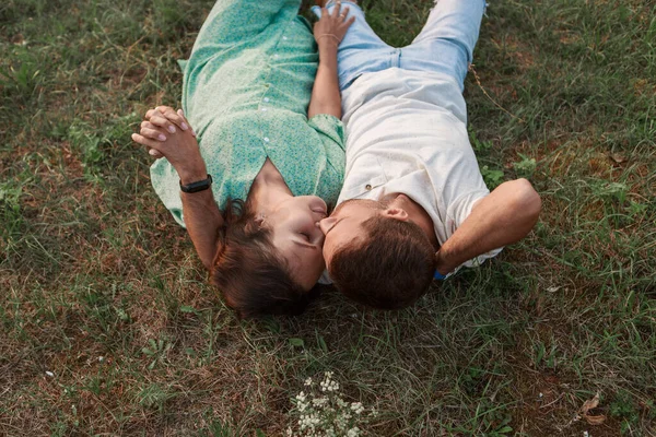 Par i kärleksfulla kramar. Man och kvinna ljuger. Alla hjärtans dag på grönt gräs — Stockfoto