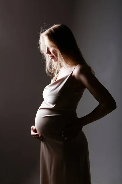 Caucasian pregnant woman stroking her belly on white background. Copy space. The concept of healthy digestion, lifestyle, IVF Royalty Free Stock Photos