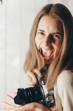 Sırt sırta kameralı kız. Beyaz arka planda bir fotoğrafçı. Kadın ve hobi