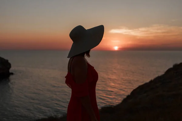 Reis naar de zee. Een meisje in een jurk en hoed loopt langs het strand. een toeristische wandeling langs de zeekust. warme tochten tijdens de vakantieperiode. kopieerruimte — Stockfoto