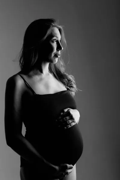 Беременная белая женщина гладит живот на белом фоне. Принято. Концепция здорового пищеварения, образа жизни, ЭКО — стоковое фото