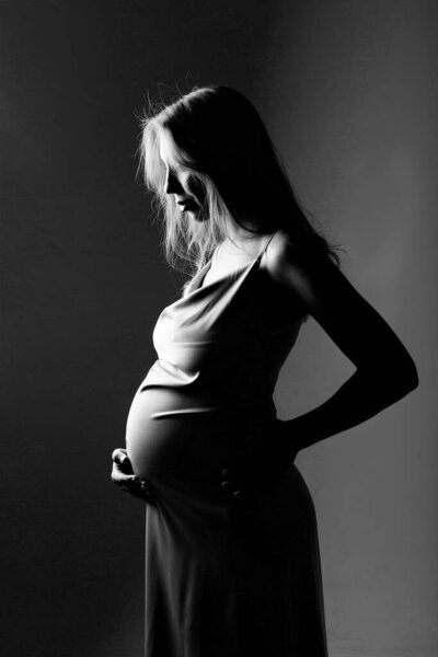 caucasian pregnant woman stroking her belly on white background. Copy space. The concept of healthy digestion, lifestyle, IVF