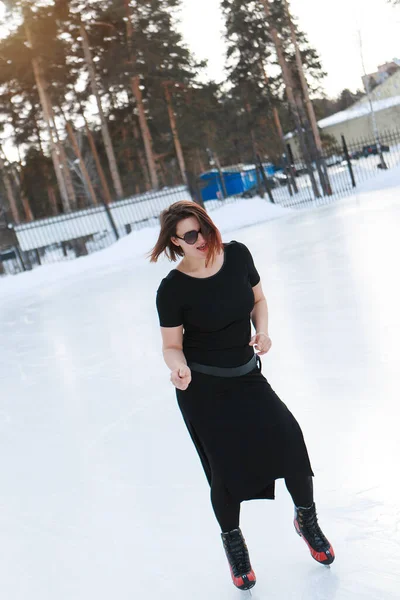 Kunstschaatser op ijs. Het meisje schaatst. ijs onder de open lucht. Geen make-up in de winter, rode wangen — Stockfoto