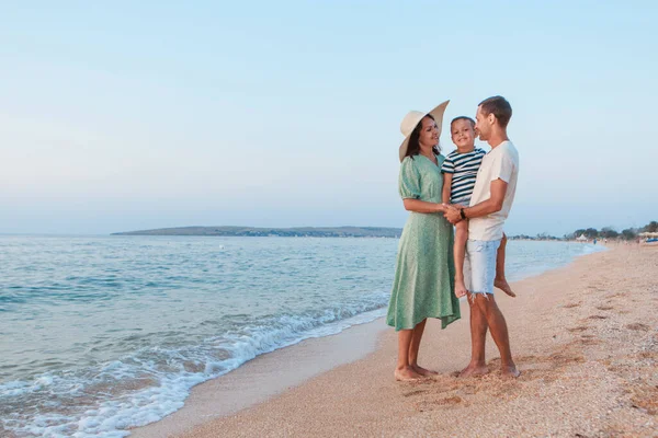 Denizde tatil. Bir aile sahil boyunca yürür. Aile el ele tutuşuyor - Stok İmaj