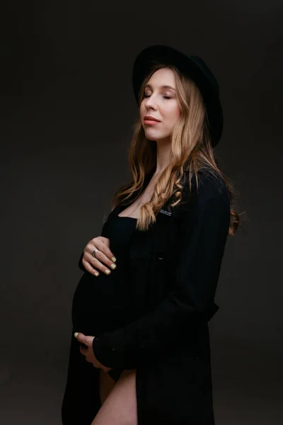 Uma mulher grávida de fato preto e chapéu preto. Espaço para copiar. O conceito de digestão saudável, estilo de vida, FIV — Fotografia de Stock