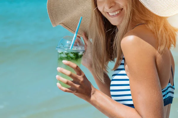 Dieta. Zdrowe jedzenie i odpoczynek. Kobieta pije koktajl w szklanym tle morza. Kobieta na plaży cieszy się życiem. — Zdjęcie stockowe