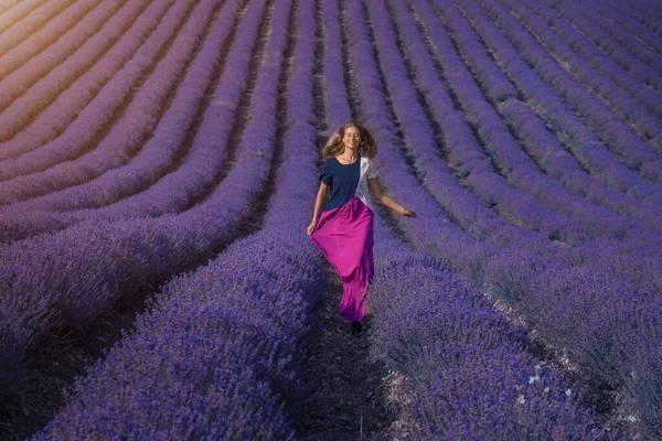 A girl in a dress on a lavender field. the woman runs. A handkerchief like wings — Stock Photo, Image