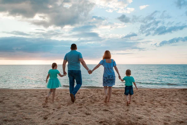 Denizde tatil. Bir aile sahil boyunca yürür. Aile el ele tutuşuyor — Stok fotoğraf