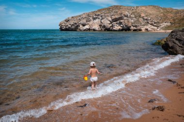 Denizde tatil. Bir kız kumsalda yürüyor.