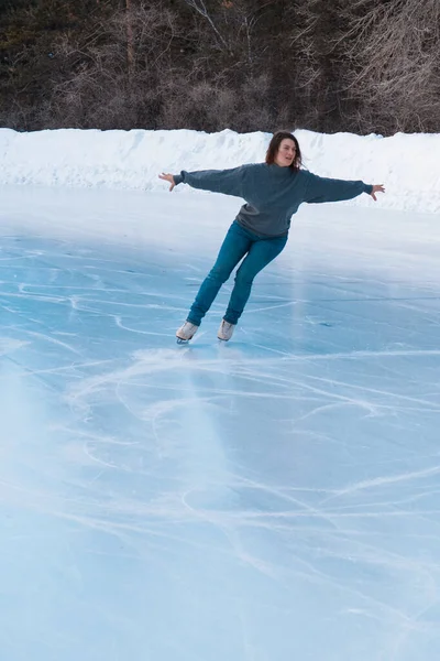 Πατινέρ στον πάγο. Το κορίτσι κάνει πατινάζ. πάγος κάτω από τον ανοιχτό ουρανό. Χωρίς μακιγιάζ το χειμώνα, κόκκινα μάγουλα — Φωτογραφία Αρχείου