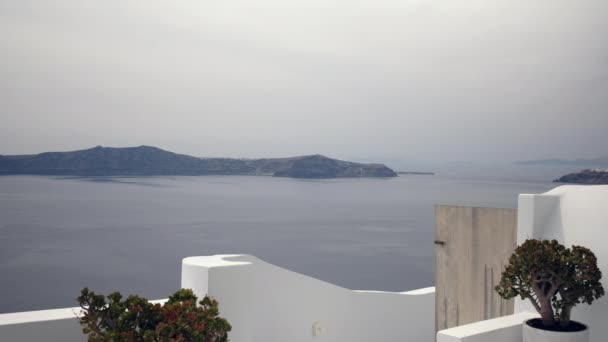 建物の屋根の上に様々な花のポットやサントリーニ島ギリシャの海の素晴らしい景色 — ストック動画